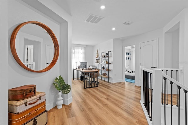 corridor with recessed lighting, visible vents, baseboards, and light wood finished floors