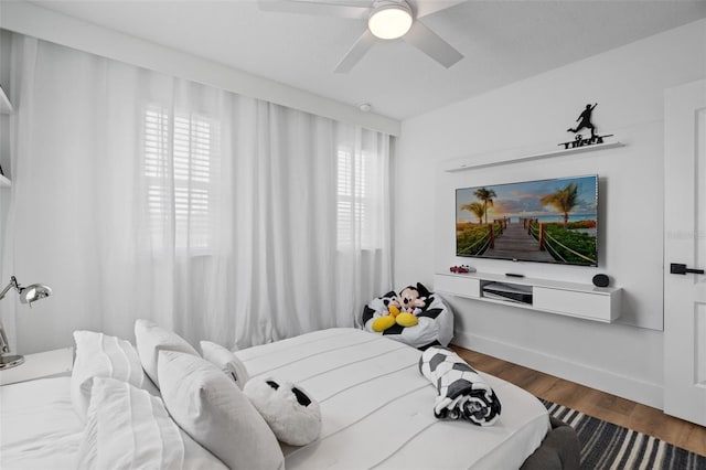 bedroom with ceiling fan, baseboards, and wood finished floors