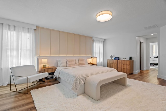 bedroom with wood finished floors and visible vents