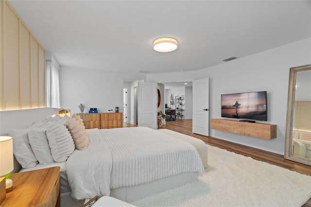 bedroom with visible vents and wood finished floors