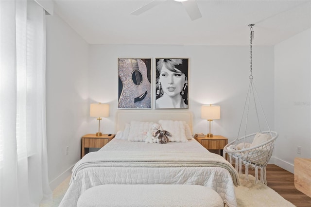 bedroom with a ceiling fan, baseboards, and wood finished floors