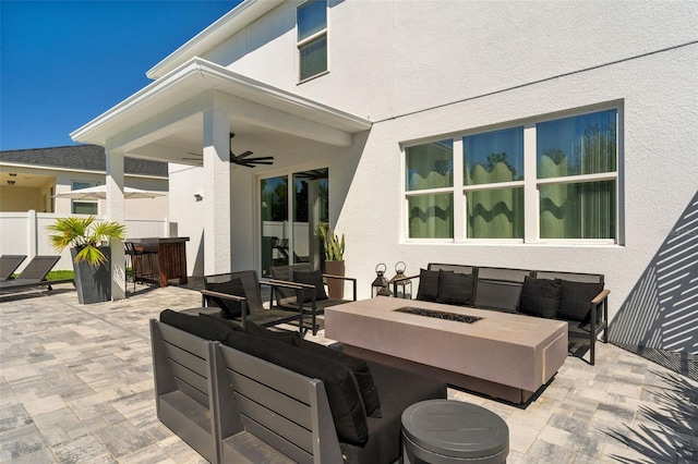 view of patio with an outdoor living space with a fire pit, outdoor dining area, fence, and ceiling fan