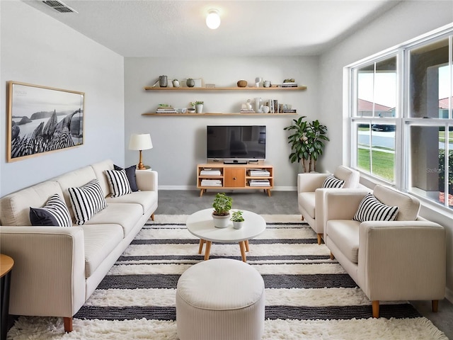 carpeted living area featuring baseboards and visible vents