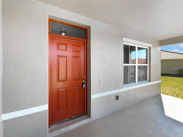 property entrance featuring stucco siding