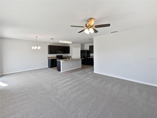 kitchen featuring visible vents, ceiling fan with notable chandelier, black appliances, light colored carpet, and open floor plan