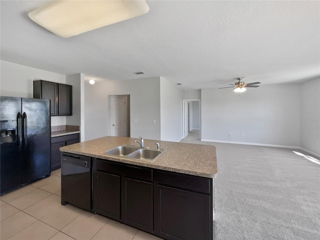 kitchen featuring black appliances, an island with sink, a sink, a textured ceiling, and ceiling fan