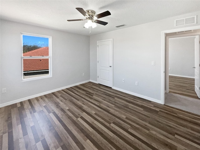 unfurnished bedroom featuring dark wood finished floors, visible vents, and baseboards