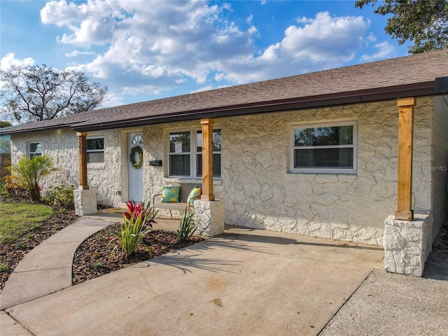 ranch-style home with stucco siding and roof with shingles