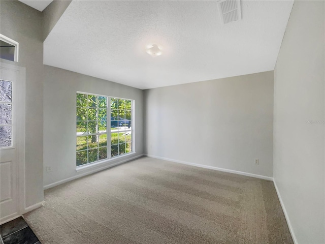 empty room featuring visible vents, a textured ceiling, baseboards, and carpet floors