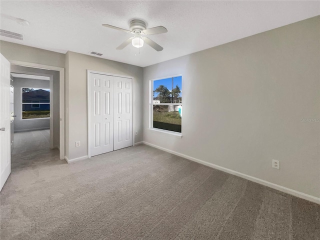 unfurnished bedroom with visible vents, baseboards, a closet, and carpet flooring