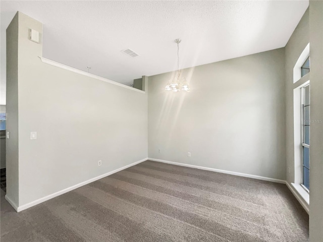 unfurnished dining area featuring a notable chandelier, visible vents, baseboards, and dark colored carpet