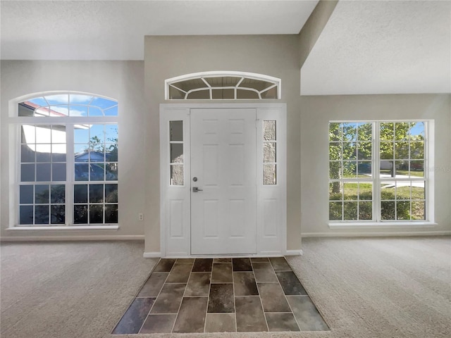 foyer with carpet flooring and baseboards