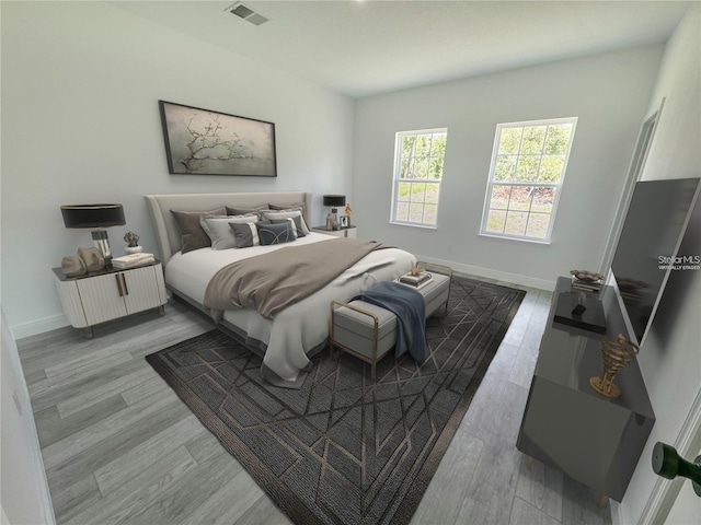 bedroom with visible vents, baseboards, and wood finished floors