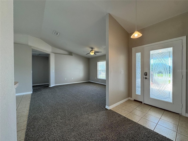 entryway featuring tile patterned flooring, visible vents, ceiling fan, carpet floors, and vaulted ceiling