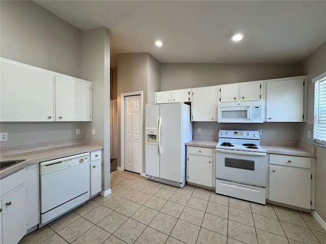 kitchen with white appliances, white cabinets, light countertops, and vaulted ceiling