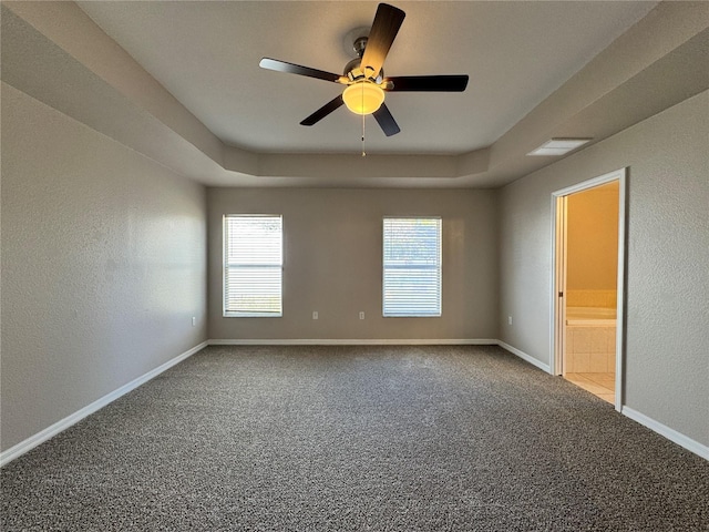 spare room with baseboards, carpet flooring, a ceiling fan, and a tray ceiling