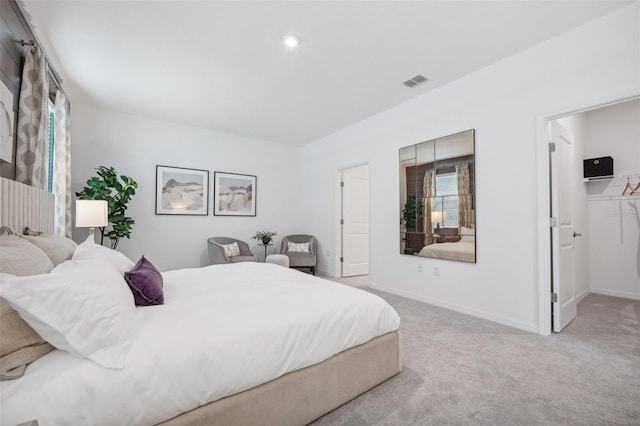 bedroom featuring a spacious closet, visible vents, baseboards, and carpet