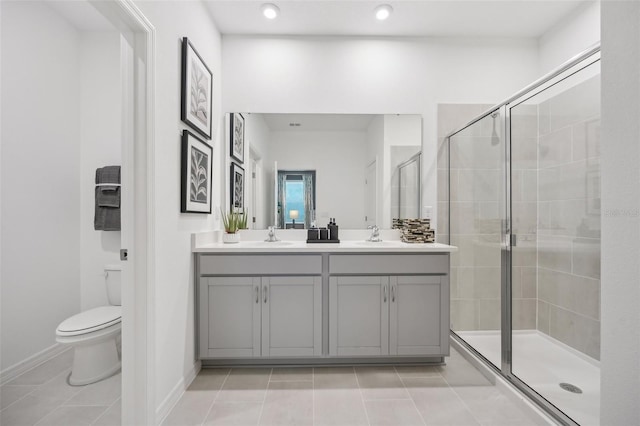 bathroom featuring double vanity, a sink, a shower stall, tile patterned floors, and toilet