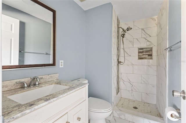 bathroom featuring marble finish floor, a stall shower, toilet, and vanity