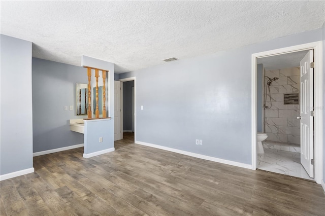 unfurnished bedroom with visible vents, baseboards, and wood finished floors