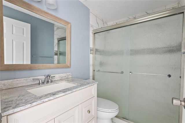 bathroom with an enclosed shower, toilet, and vanity