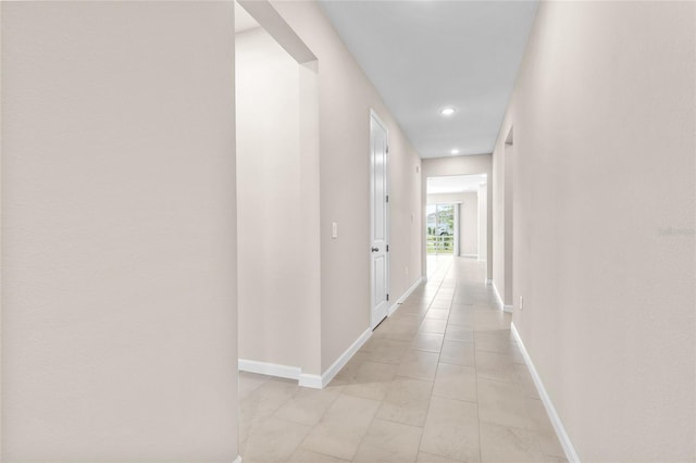 hallway with light tile patterned flooring, recessed lighting, and baseboards