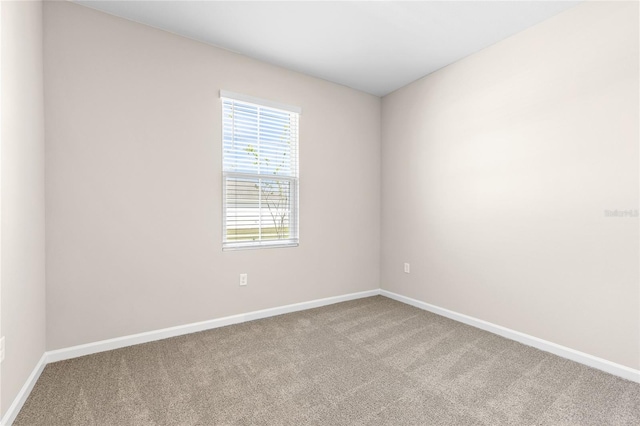 carpeted spare room with baseboards