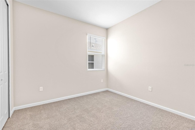 carpeted spare room featuring baseboards