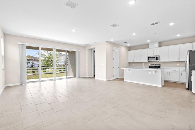 kitchen with visible vents, stainless steel appliances, light countertops, and open floor plan