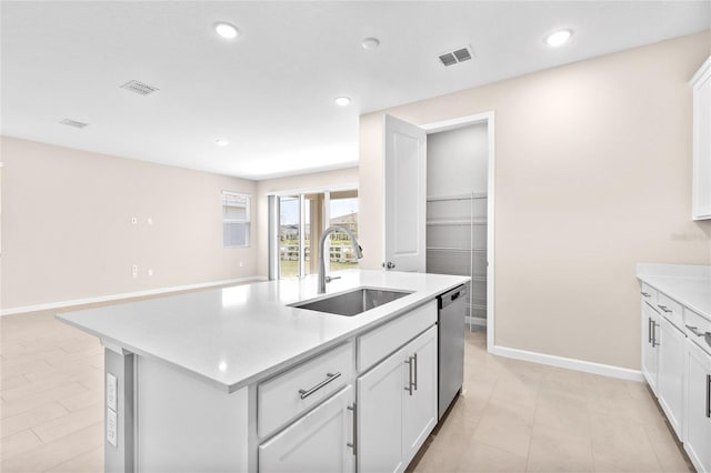 kitchen featuring stainless steel dishwasher, light countertops, visible vents, and a sink