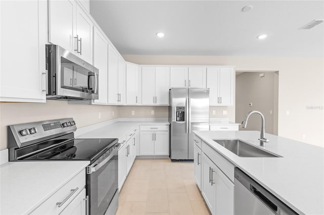 kitchen featuring visible vents, stainless steel appliances, light countertops, and a sink