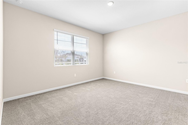 unfurnished room with baseboards and carpet floors