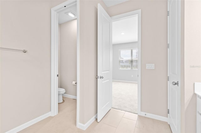 bathroom with tile patterned floors, toilet, vanity, and baseboards