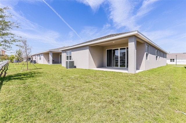 rear view of property featuring stucco siding, a yard, and cooling unit