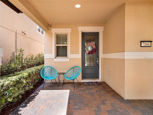 doorway to property featuring a patio and stucco siding