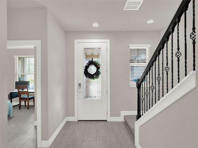 foyer with recessed lighting, visible vents, baseboards, and stairs