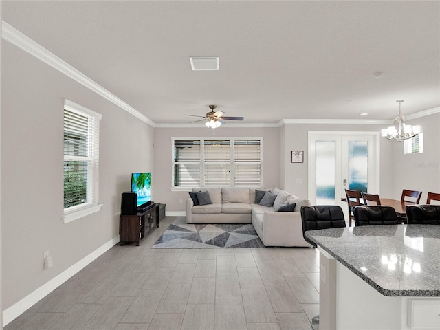 living area with visible vents, plenty of natural light, baseboards, and crown molding