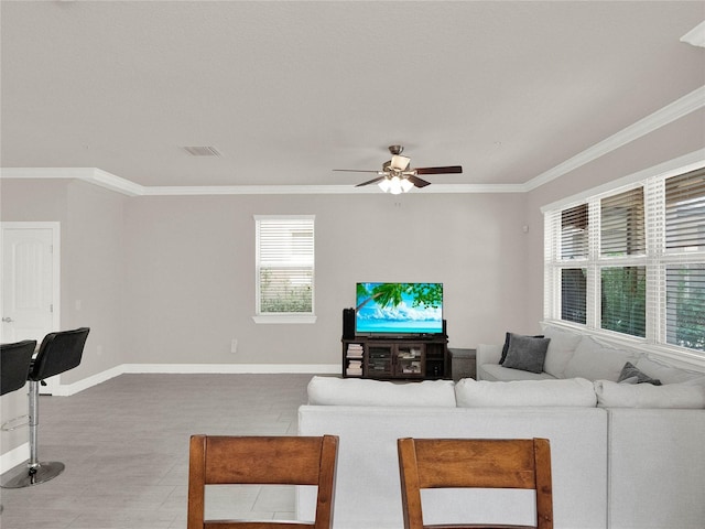 living area featuring visible vents, baseboards, ornamental molding, and a ceiling fan