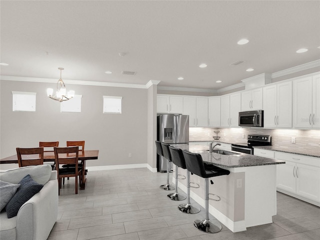 kitchen with a sink, visible vents, backsplash, and stainless steel appliances