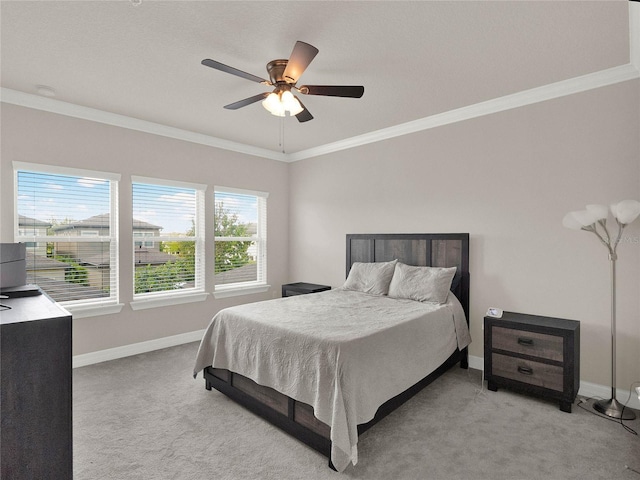 bedroom featuring ceiling fan, baseboards, light colored carpet, and ornamental molding