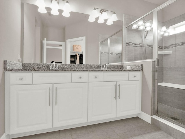 full bathroom featuring a sink, a shower stall, and double vanity