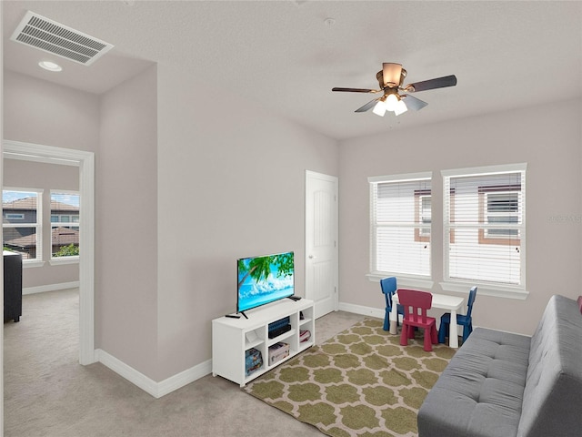 living room with visible vents, baseboards, carpet, and ceiling fan