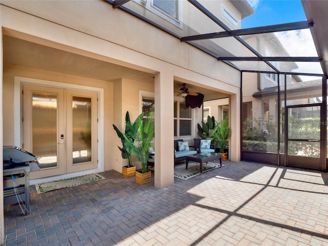 view of patio / terrace with a ceiling fan, a lanai, and french doors