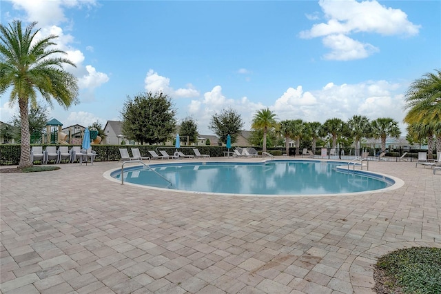 community pool featuring a patio and fence