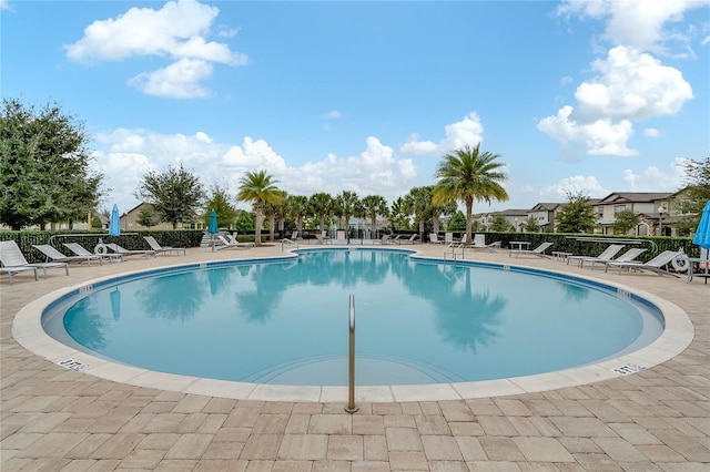 community pool with a patio and fence