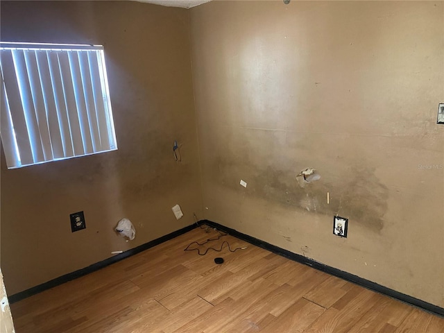 laundry room featuring wood finished floors and baseboards