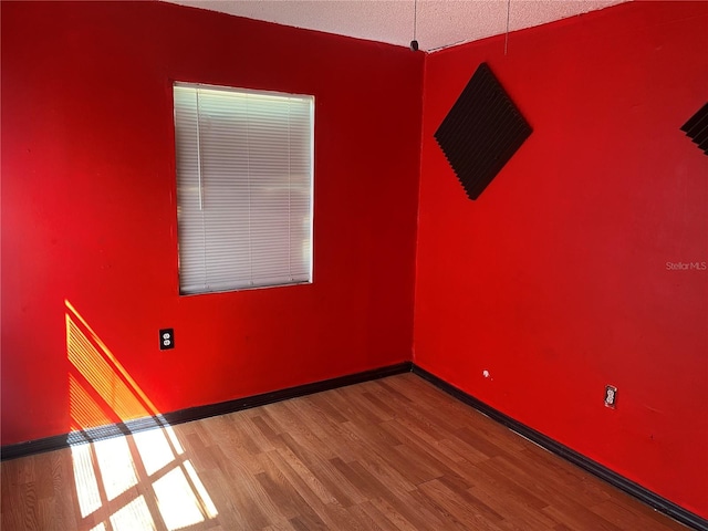 unfurnished room featuring wood finished floors and baseboards