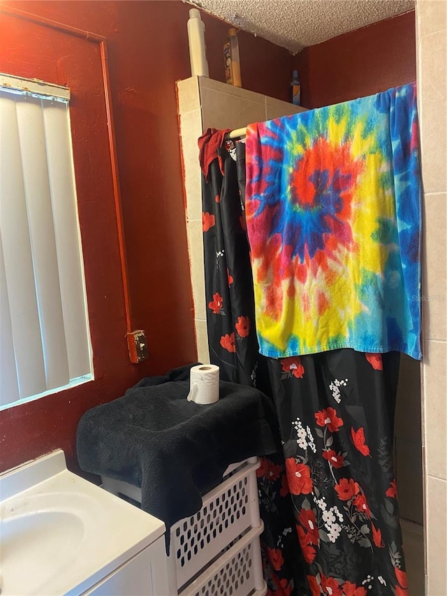 bathroom featuring curtained shower, a textured ceiling, and vanity