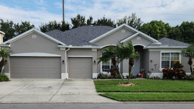 ranch-style home with stucco siding, driveway, a front lawn, a shingled roof, and a garage