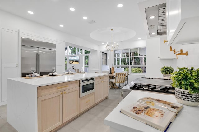 kitchen with built in appliances, recessed lighting, light countertops, a center island, and hanging light fixtures